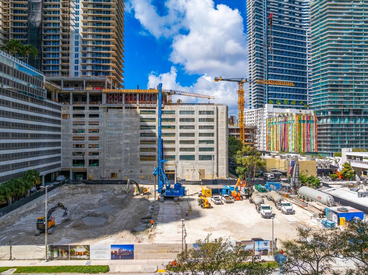 Obra de The Residences at 1428 Brickell en Miami, con maquinaria de construcción y edificios vecinos.