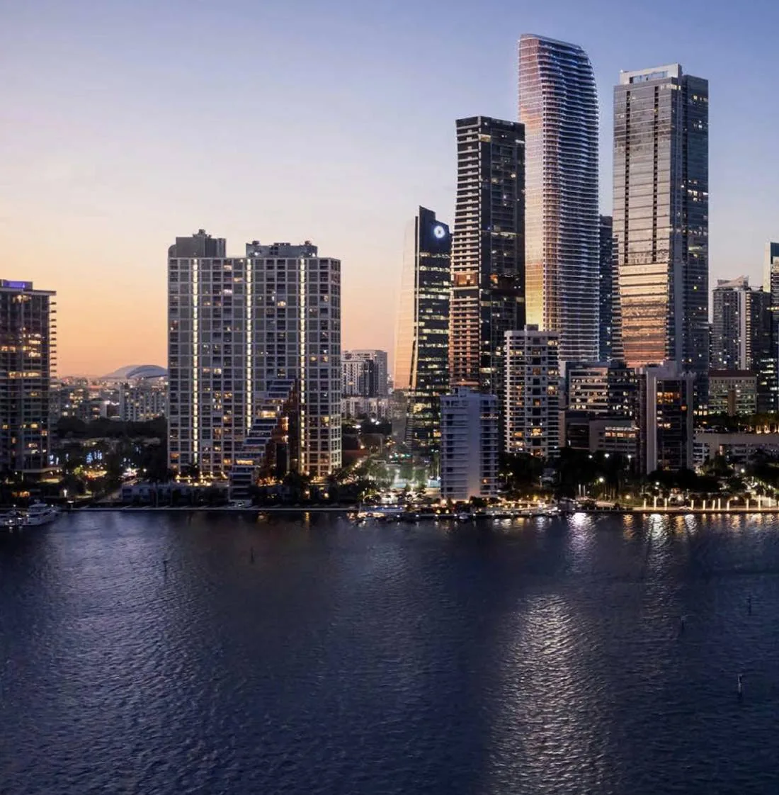 The Residences at 1428 Brickell Ave rising over the Brickell skyline and Biscayne Bay at dusk &mdash; artist's conceptual rendering