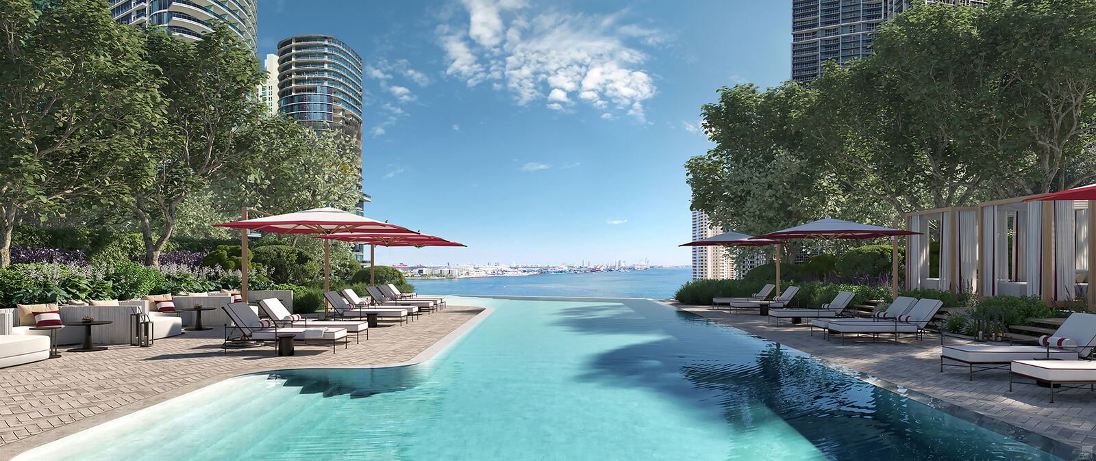 Riverfront pool with signature red umbrellas overlooking Biscayne Bay at Baccarat Residences Miami