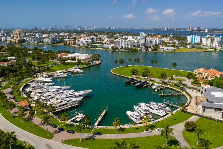 Aerial view of a Bal Harbour yacht marina ringed by luxury homes and waterfront residences in Florida
