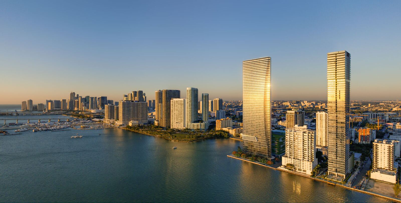 Vista a&eacute;rea al atardecer de la torre de cristal de EDITION Residences sobre la costa de Edgewater en Biscayne Bay