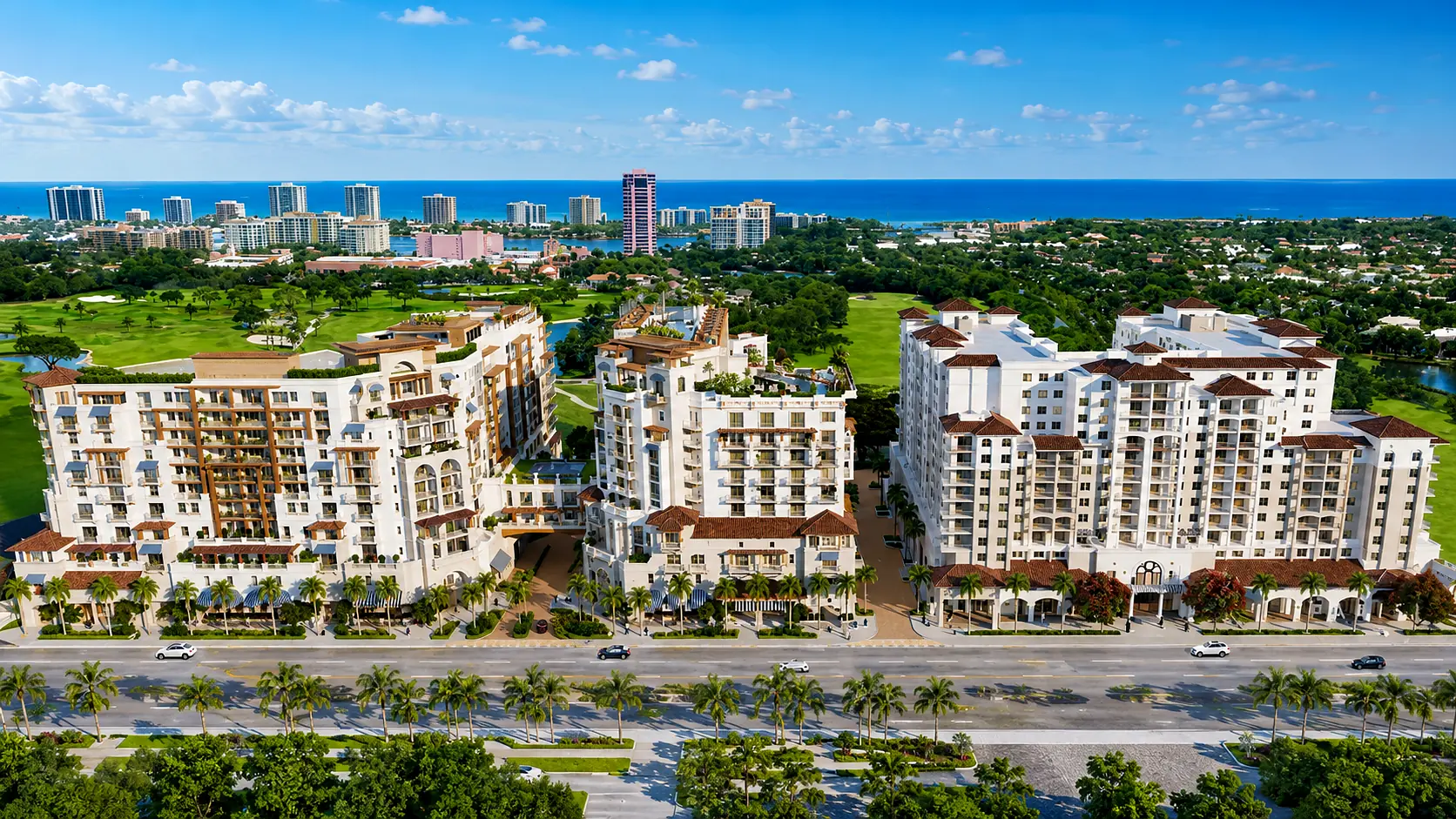 Aerial view of a Mediterranean-style luxury development in downtown Boca Raton, Florida, with the Intracoastal Waterway and Atlantic Ocean beyond