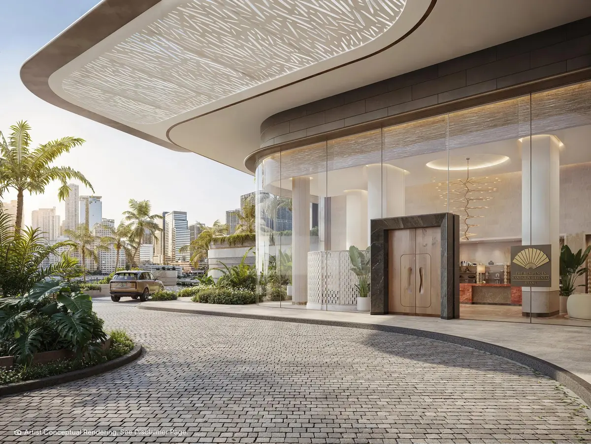 Render del desarrollador de la entrada vehicular curva y el lobby residencial de vidrio de The Residences at Mandarin Oriental, Miami en Brickell Key