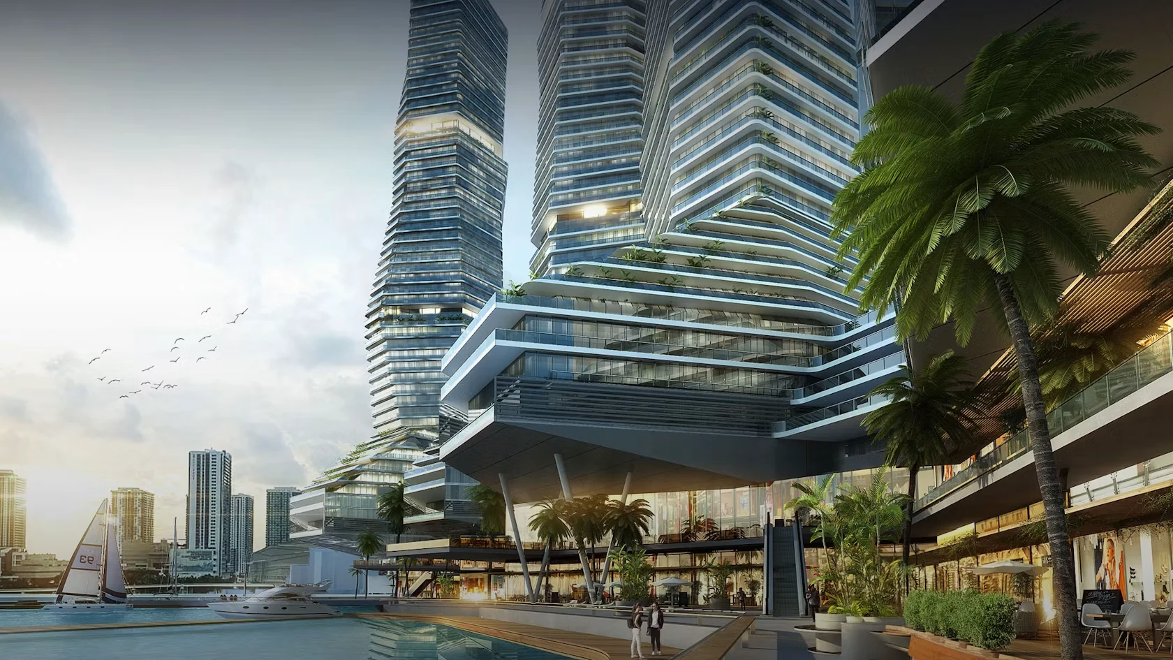Concept rendering of the waterfront podium level of Miami Bay Towers, showing a shaded pedestrian walkway, commercial frontage, planted terraces and moored boats on Biscayne Bay