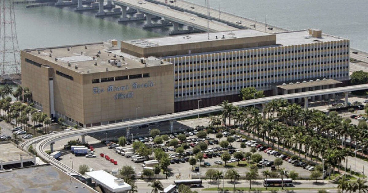 Aerial photograph of the former Miami Herald headquarters building on Biscayne Bay in Miami before its demolition, with the causeway bridge behind it