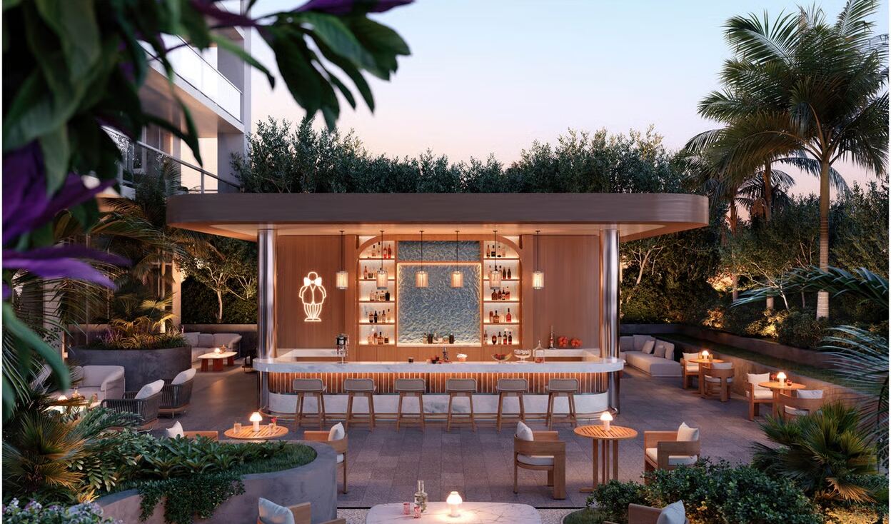 Garden cocktail bar glowing at dusk with the Mr. C neon emblem at Mr. C Residences West Palm Beach