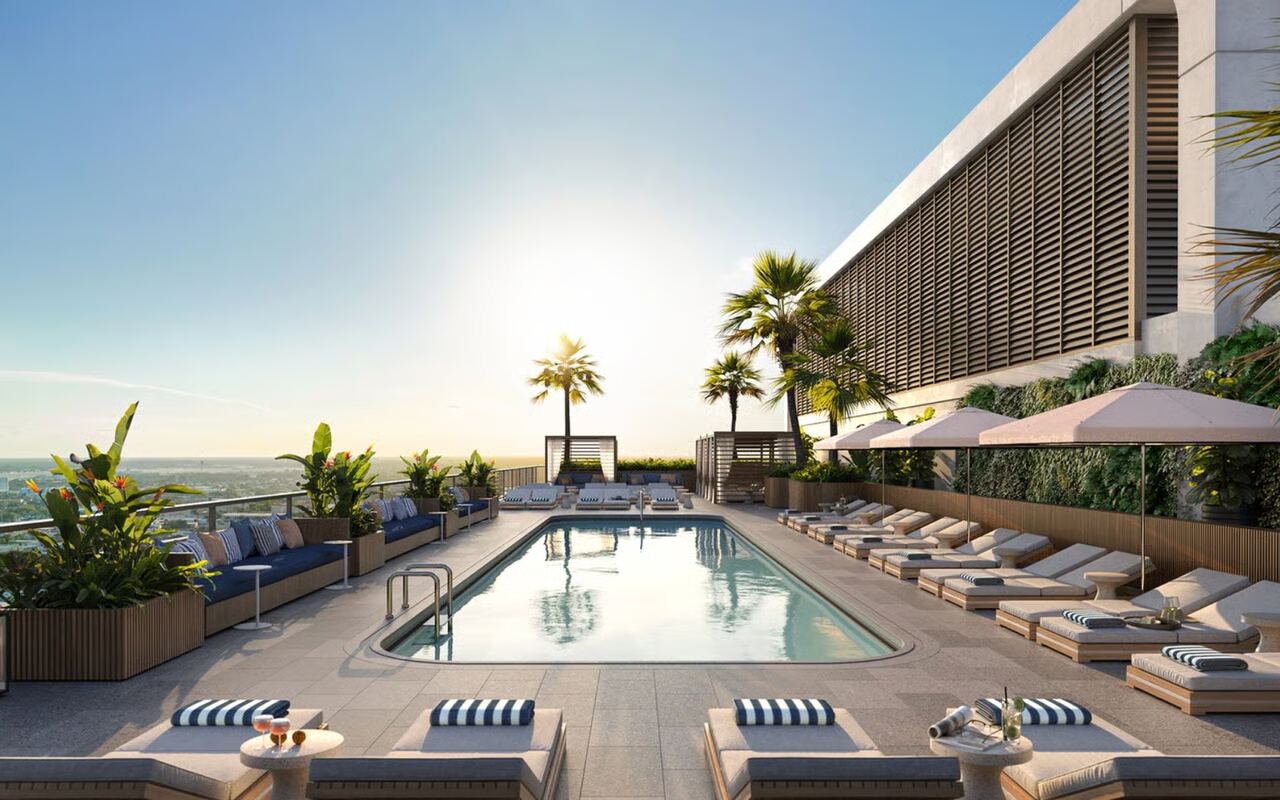 Rooftop pool deck with cabanas and striped loungers overlooking downtown West Palm Beach at Mr. C Residences