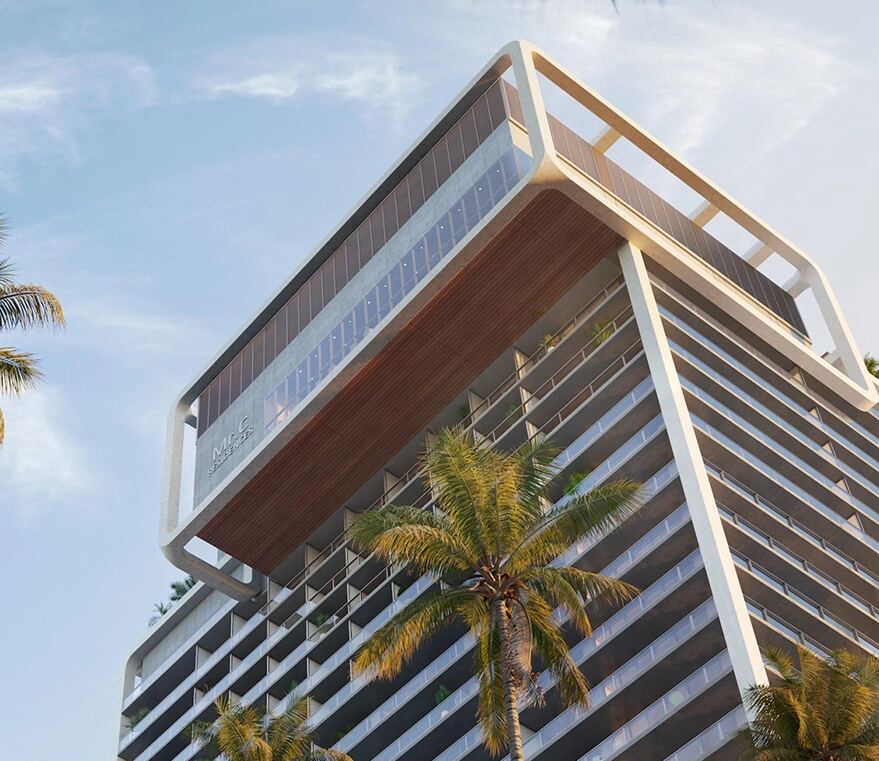 Sculpted crown of the Mr. C Residences West Palm Beach tower framed by palm trees in downtown West Palm Beach