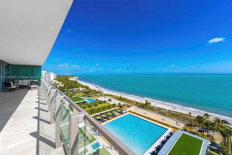 Vista desde una terraza de Oceana Key Biscayne sobre las piscinas frente al mar, la playa privada y el turquesa océano Atlántico