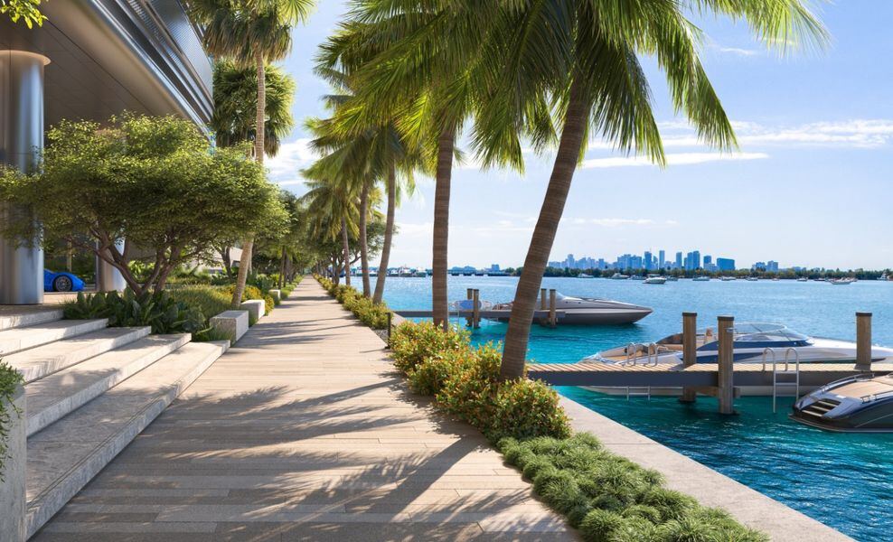 Palm-lined waterfront boardwalk and private marina with the Miami skyline beyond at Pagani Residences North Bay Village