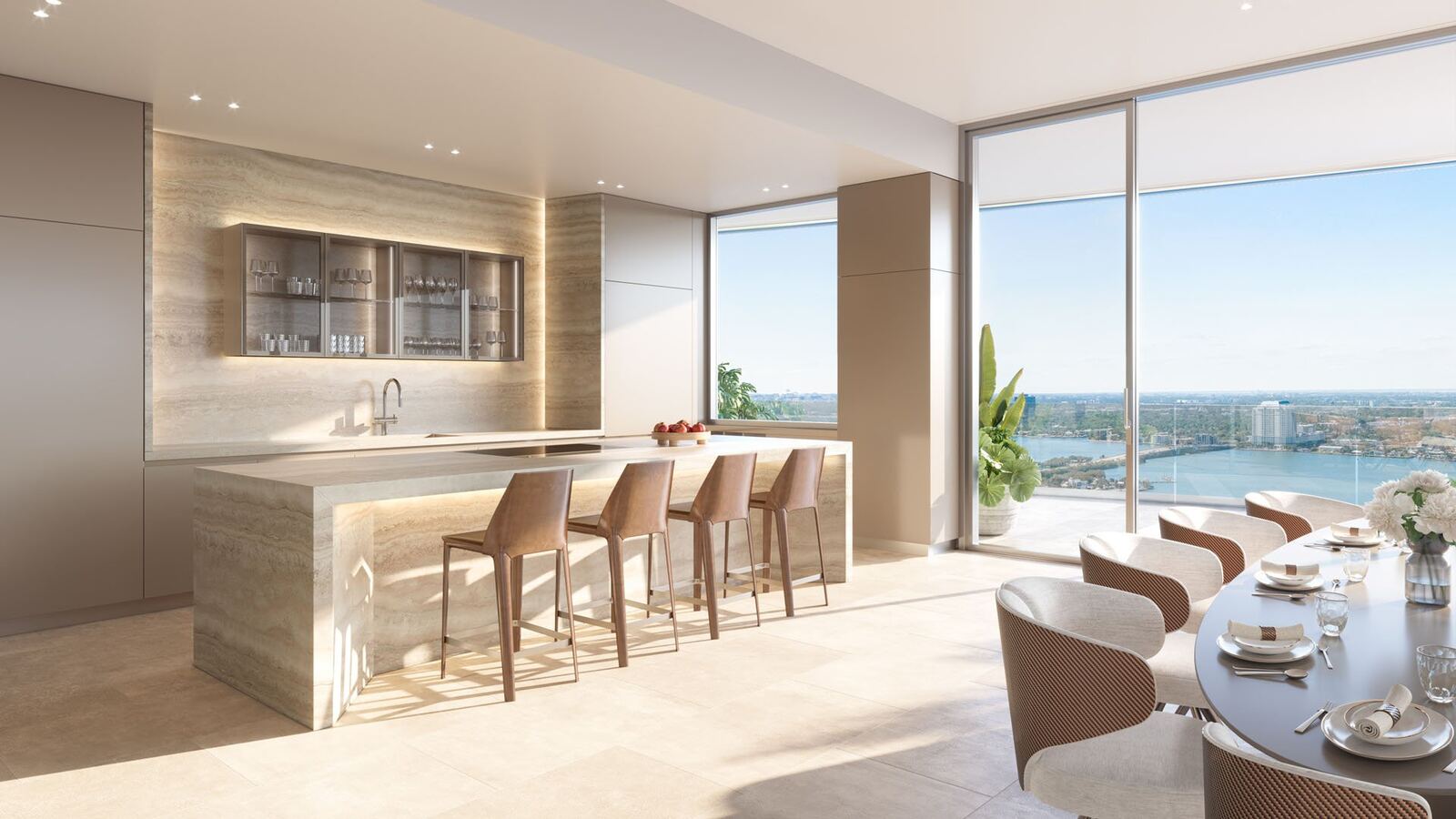 Travertine kitchen island with leather barstools and bay views inside a Pagani Residences North Bay Village home