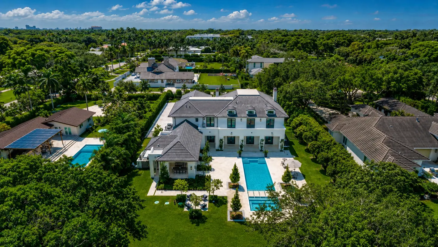 Aerial view of a Pinecrest luxury estate on a large lot with pool, terrace and lawn, surrounded by mature tree canopy and neighbouring single-family homes