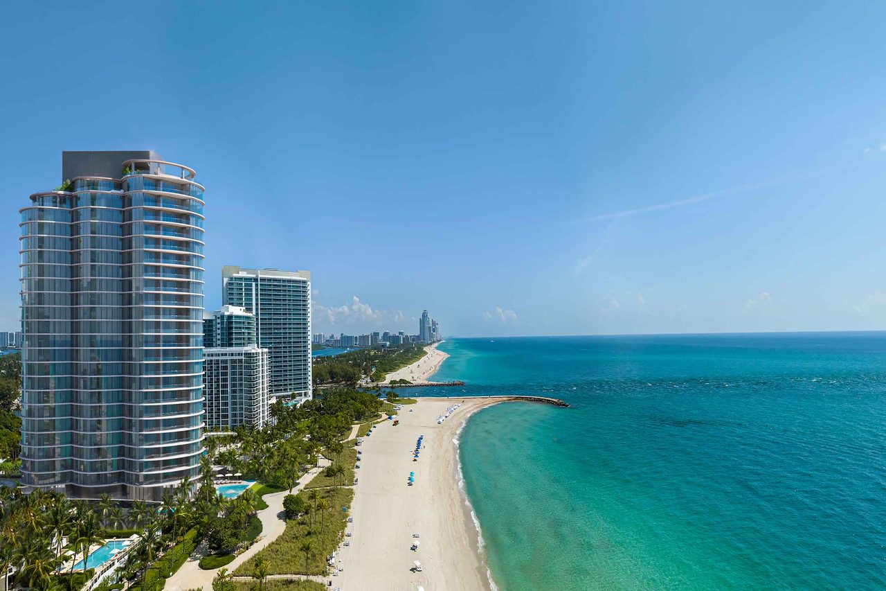 Vista a&eacute;rea de Rivage Bal Harbour elev&aacute;ndose sobre la arena con el Atl&aacute;ntico turquesa y la entrada de Haulover al fondo