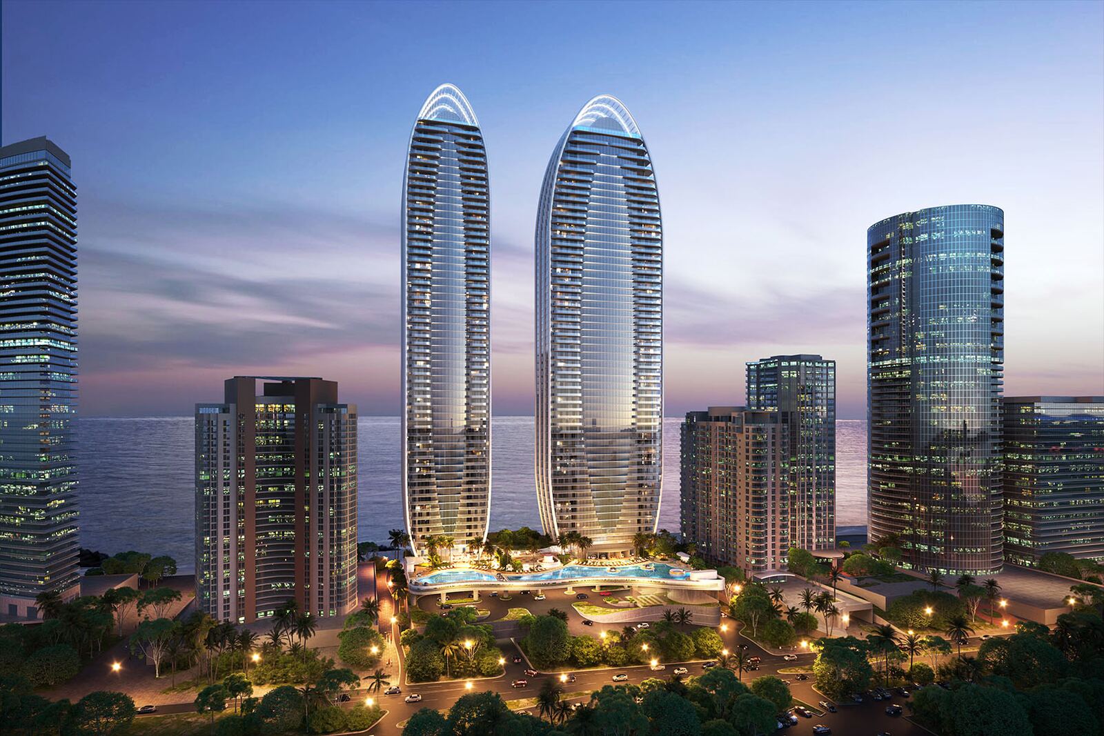 Twin curvilinear towers of The St. Regis Residences Sunny Isles Beach glowing at dusk on the oceanfront skyline