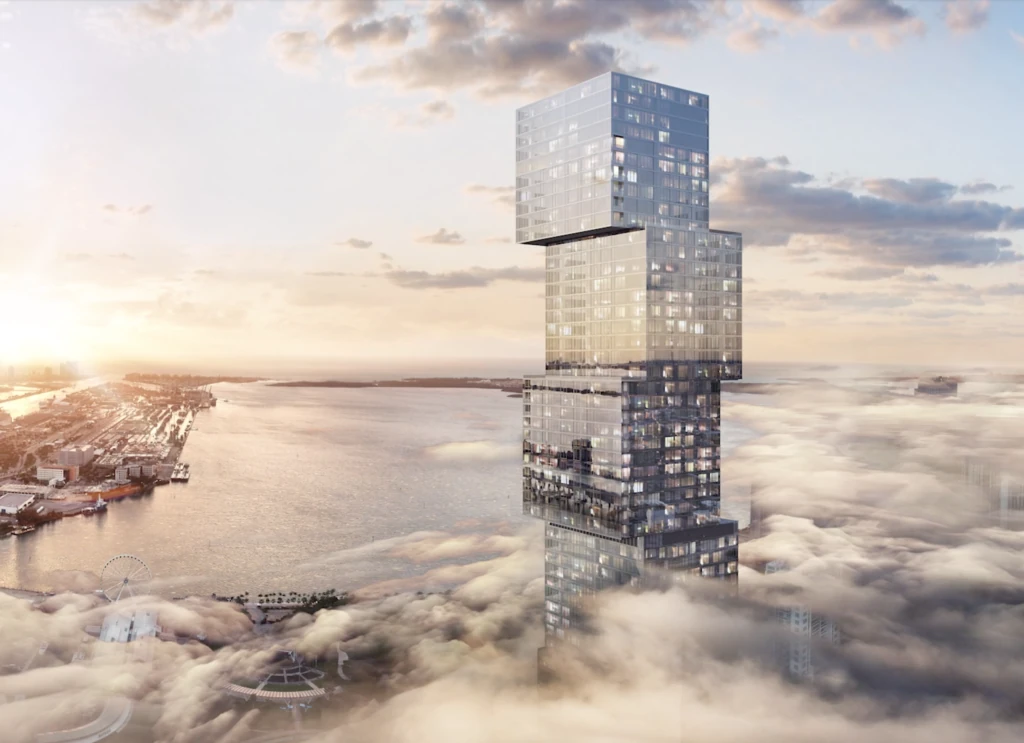 Developer rendering of the completed Waldorf Astoria Hotel and Residences Miami showing nine offset glass cubes above the clouds with Biscayne Bay and Miami Beach beyond