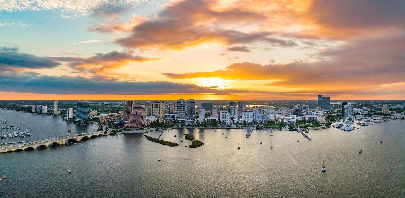 Horizonte del centro de West Palm Beach al atardecer sobre la v&iacute;a fluvial Intracoastal, con embarcaciones y el puente hacia la isla de Palm Beach, Florida